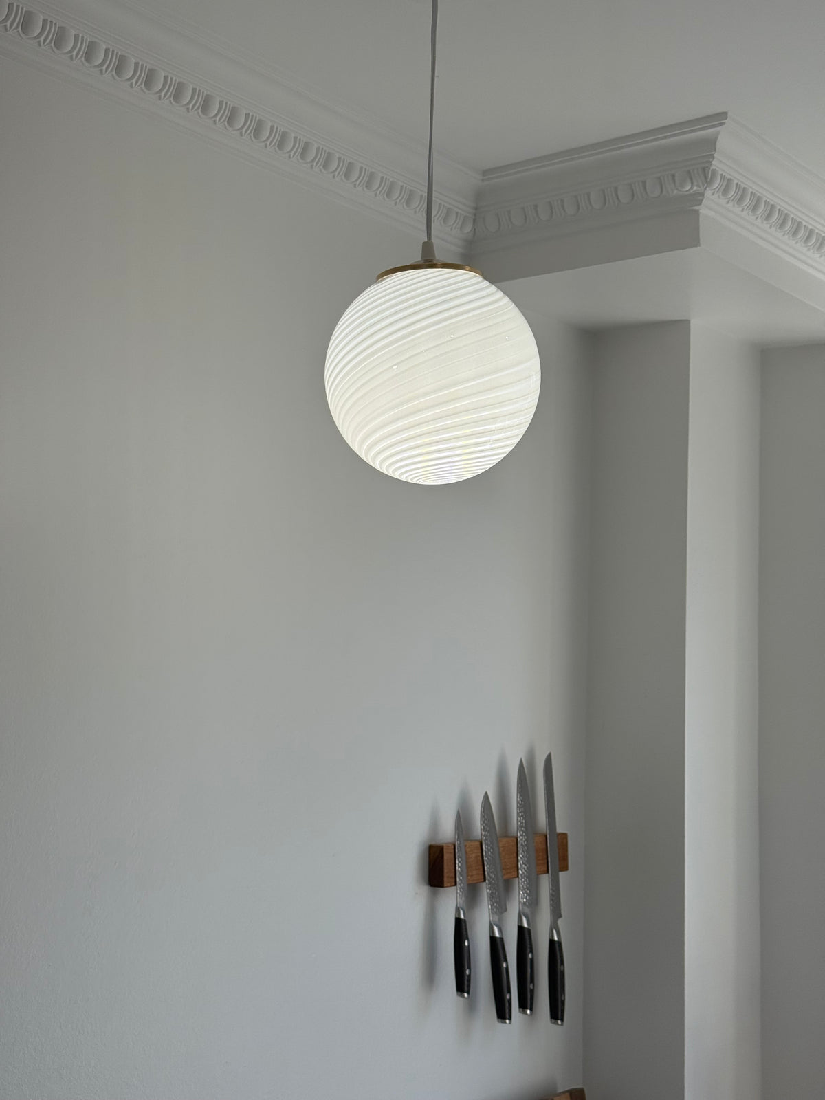 Hvid vintage Murano mini pendel med swirl-mønster hængende i et køkken