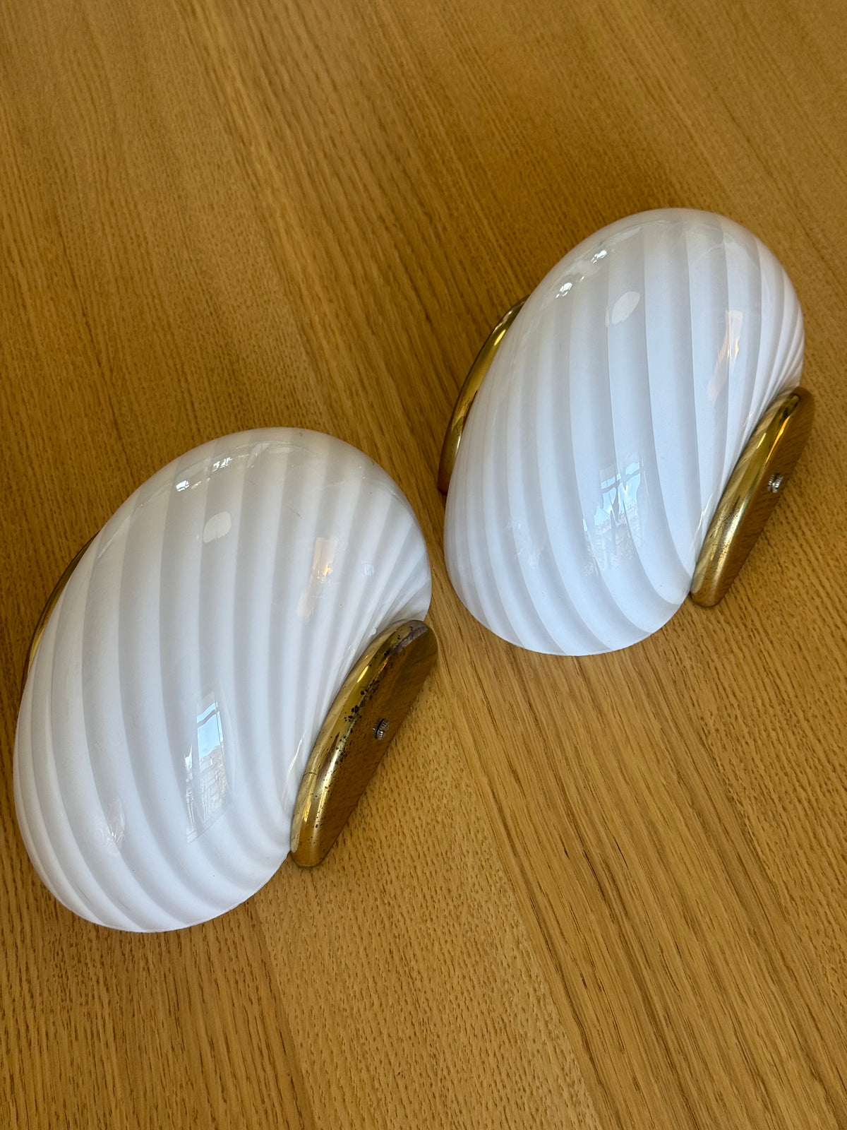 Et par ens vintage Murano væglamper i hvidt swirl-glas med messingbeslag