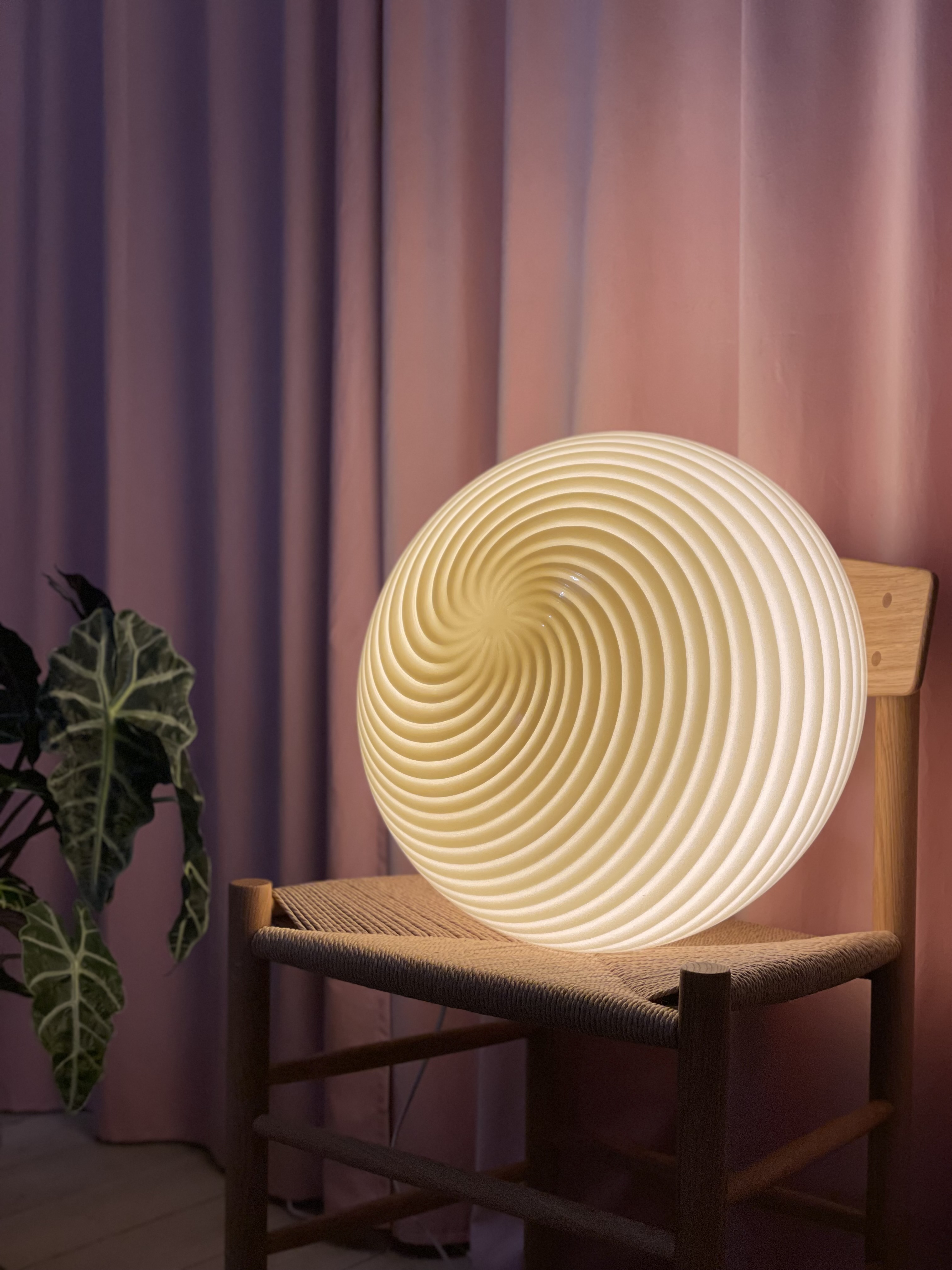 Murano bordlampe med swirl-mønster foran et gardin