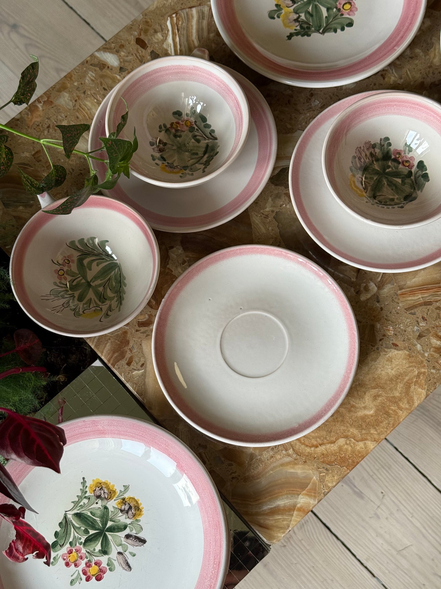 Thesæt med lyserød kant og blomster