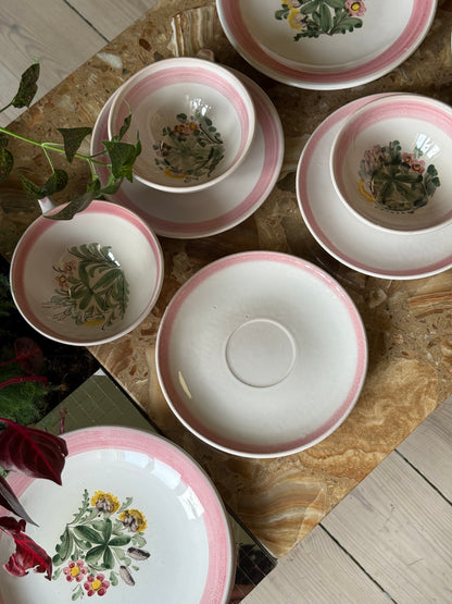 Thesæt med lyserød kant og blomster