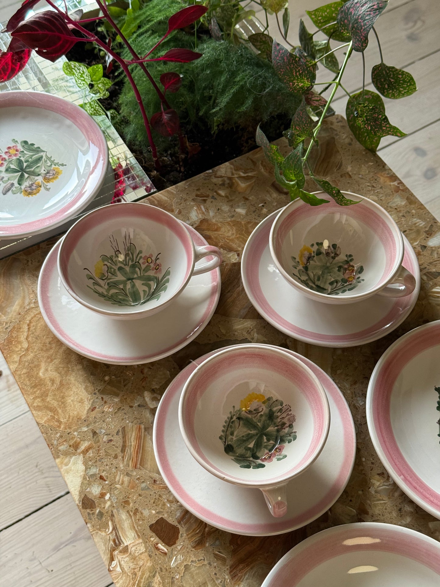 Thesæt med lyserød kant og blomster