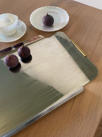 Large steel dish with gold handles and engraved details