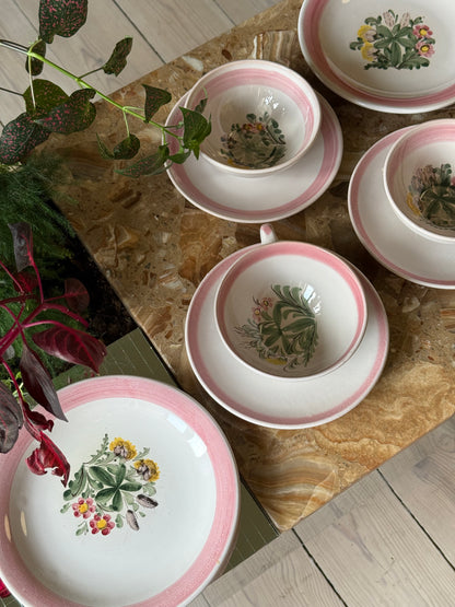 Thesæt med lyserød kant og blomster